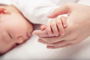 hand the sleeping baby in the hand of mother close up (soft focu