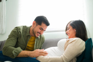 side view of an attractive pregnant couple relaxing at home